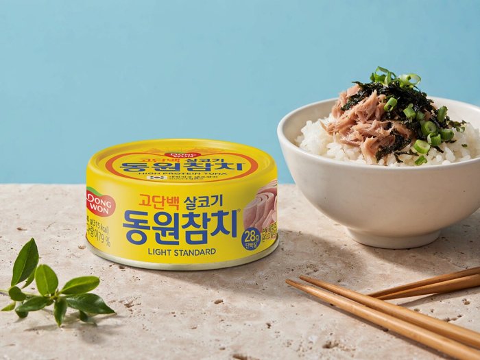 참치캔의 노란 패키지와 로고는 유지하고 배경을 참치 덮밥과 하늘색 톤으로 바꾼 광고 이미지